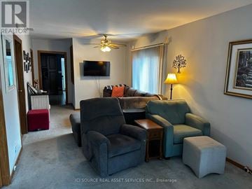 Windsor apartment for rent - A living room with a grey couch, a black chair and a red ottoman.