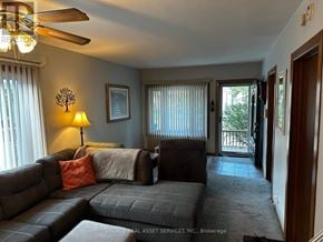Windsor apartment for rent - A living room with a grey couch and a ceiling fan.