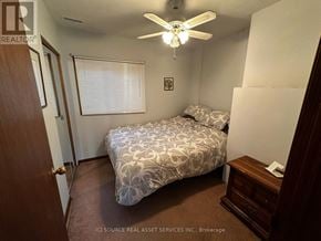 Windsor apartment for rent - A bedroom with a bed, dresser, and ceiling fan.