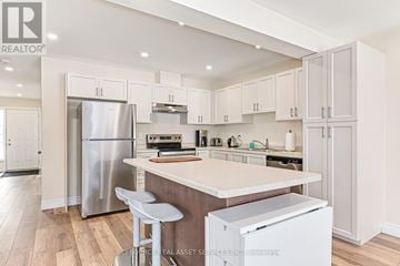 Meaford townhouse for rent - A kitchen with white cabinets and a wooden island.