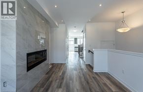 Paris townhouse for rent - A spacious hallway with a fireplace and wood flooring.