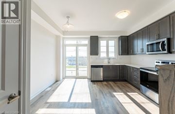 Paris townhouse for rent - A well-lit kitchen with dark wood cabinets and a white door.