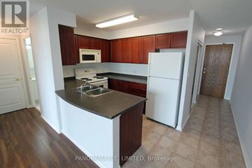 Mississauga (Central Erin Mills) condo for rent - A kitchen with brown cabinets and a white fridge.