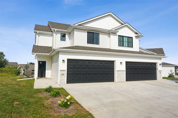 Des Moines apartment for rent - A two-story house with a white exterior and black garage doors.