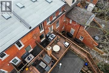 Hamilton townhouse for rent - A bird's eye view of a red brick house with a wooden deck and a satellite dish on the roof.