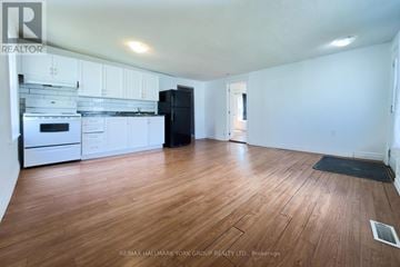 Barrie (Allandale Centre) apartment for rent - A kitchen with white cabinets and a black fridge is shown.