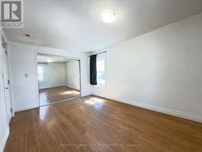 Barrie (Allandale Centre) apartment for rent - A spacious room with wooden flooring and white walls.