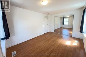 Barrie (Allandale Centre) apartment for rent - A room with wooden flooring and white walls, with a door and a window.