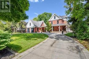 Oakville (Sw Southwest) apartment for rent - A large, two-story house with a driveway in front is surrounded by greenery.