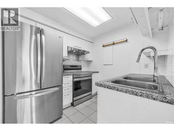 Vancouver apartment for rent - A modern kitchen with a stainless steel refrigerator and granite countertop.