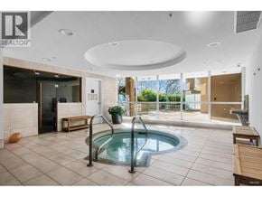 Vancouver apartment for rent - A large indoor swimming pool with a hot tub in the middle of the room.