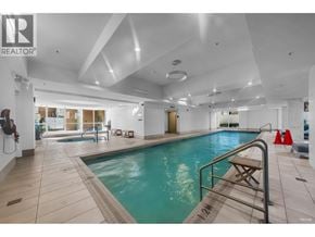 Vancouver apartment for rent - A large indoor swimming pool with a diving board and a bench.