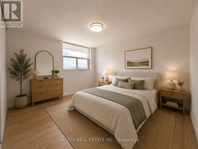Mississauga (Port Credit) condo for rent - A bedroom with a bed, nightstand, and a plant.