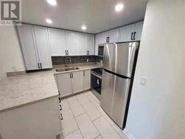 Toronto (Rosedale-Moore Park) condo for rent - A kitchen with white cabinets and a stainless steel refrigerator.