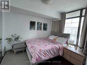 Toronto (Church-Yonge Corridor) condo for rent - A bedroom with a pink bedspread and a grey ottoman.