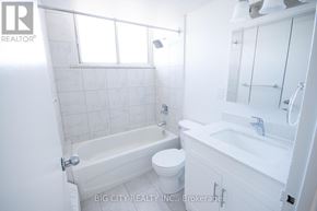 Toronto (East York) condo for rent - A white bathroom with a toilet, sink, and bathtub.