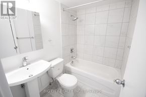 Toronto (East York) condo for rent - A white bathroom with a toilet, sink, and bathtub.