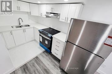 Hamilton (Stoney Creek) apartment for rent - A kitchen with white cabinets and a stainless steel refrigerator.