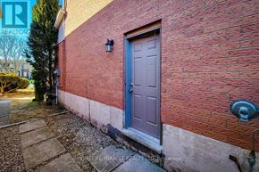Hamilton (Stoney Creek) apartment for rent - A red brick building with a grey door and a small window above it.