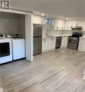 Hamilton (Berrisfield) apartment for rent - A kitchen with white cabinets and a black stove top oven.