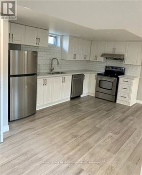 Hamilton (Berrisfield) apartment for rent - A kitchen with white cabinets and a wooden floor.