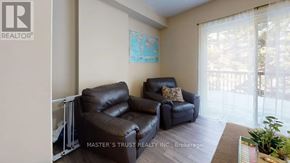 Waterloo townhouse for rent - A living room with a couch and a plant.