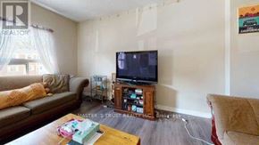 Waterloo townhouse for rent - A living room with a brown couch, a wooden coffee table, and a flat screen TV.