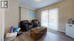 Waterloo townhouse for rent - A living room with a black leather couch and a white cabinet.