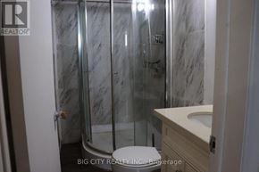 Toronto (L'amoreaux) apartment for rent - A bathroom with a marble wall and a glass shower door.