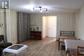 Toronto (L'amoreaux) apartment for rent - A room with a bed, a chair, and a table is shown.