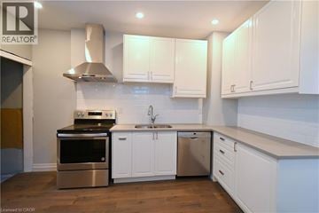 Hamilton apartment for rent - A modern kitchen with white cabinets and stainless steel appliances.