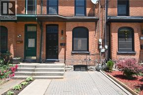 Hamilton apartment for rent - A red brick building with a green door and a sign that says REALTOR.
