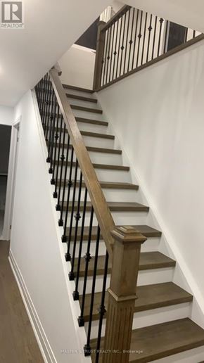 Toronto (Tam O'shanter-Sullivan) apartment for rent - A staircase with a wooden handrail and white walls.