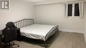 Toronto (Tam O'shanter-Sullivan) apartment for rent - A bedroom with a white bed and a black chair.