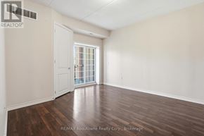 Guelph (Kortright West) condo for rent - A room with wooden floors and a white door leading to a balcony.