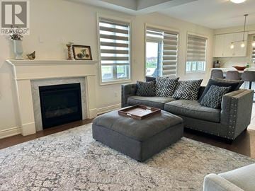 Hamilton (Waterdown) apartment for rent - A living room with a grey couch and a fireplace.