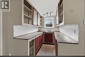 Port Coquitlam apartment for rent - A kitchen with white cabinets and a red counter.