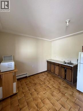 Burnaby apartment for rent - A kitchen with a white fridge and wooden floors.