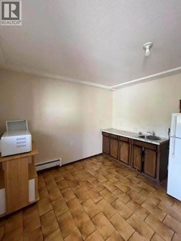 Burnaby apartment for rent - A kitchen with a white fridge and wooden floors.