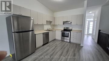 Brantford townhouse for rent - A modern kitchen with stainless steel appliances and white cabinets.