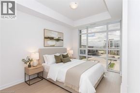 Stoney Creek condo for rent - A bedroom with a large bed and a view of the outside.
