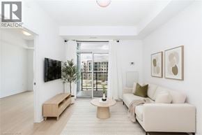 Stoney Creek condo for rent - A living room with a white couch, a wooden coffee table, and a flat-screen TV mounted on the wall.