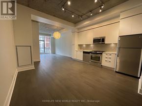 Toronto (Waterfront Communities) condo for rent - A spacious kitchen with stainless steel appliances and wooden flooring.