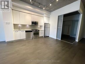 Toronto (Waterfront Communities) condo for rent - A kitchen with white cabinets and a wooden floor.