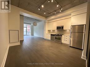 Toronto (Waterfront Communities) condo for rent - A spacious kitchen with stainless steel appliances and wooden flooring.
