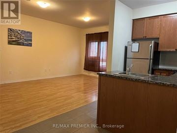 Toronto (Westminster-Branson) townhouse for rent - A kitchen area with wooden cabinets and a refrigerator.