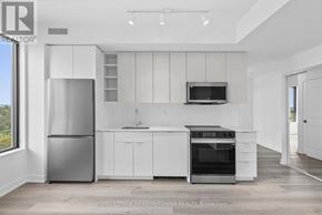 Burlington (Brant) condo for rent - A modern kitchen with white cabinets and stainless steel appliances.