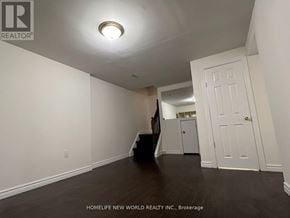Toronto (L'amoreaux) apartment for rent - A white door is on the right side of a room with a wooden floor.