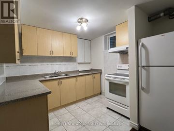 Toronto (L'amoreaux) apartment for rent - A kitchen with wooden cabinets and a white refrigerator.