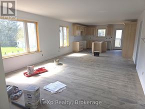 South Bruce multi-family for rent - A room with wooden flooring and unfinished walls is shown.